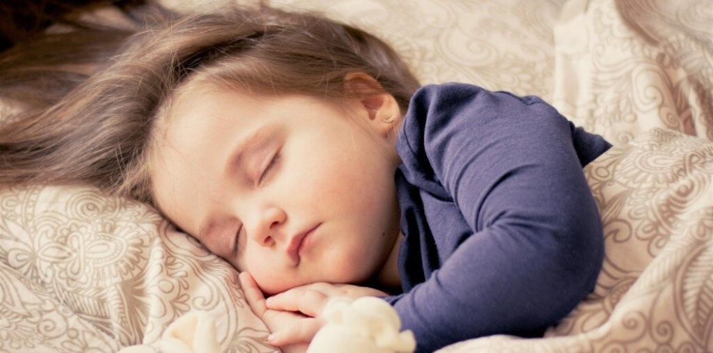 A child sleeping in a bed alone