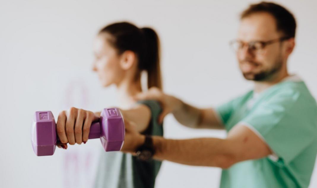 A physiotherapist guiding a patient through exercise rehabilitation