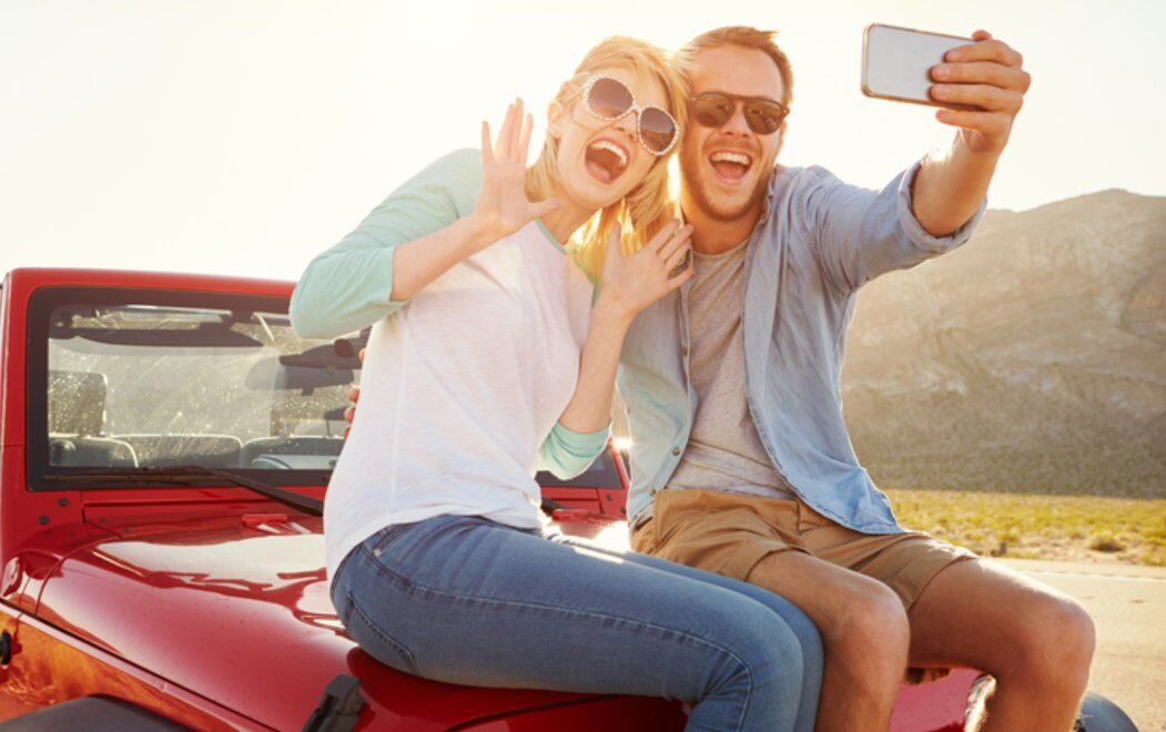 couple taking selfie on convertible