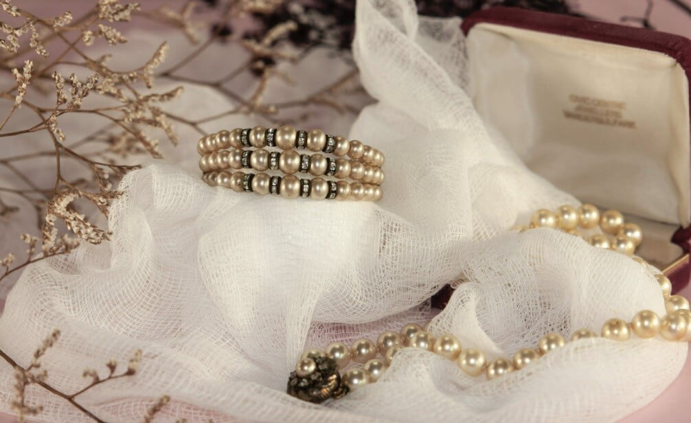 jewelry bangles and chains placed on a silky cloth on a table