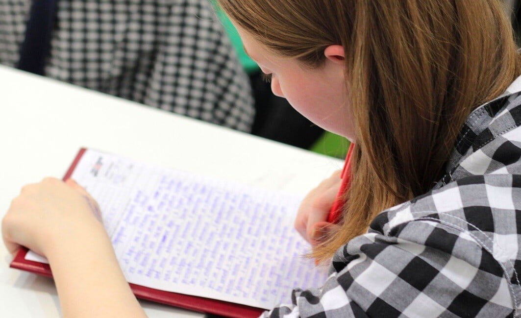 nursing student writing on a notebook with a pen as part of her studies
