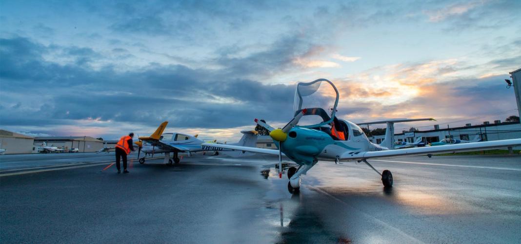 a jet parked on the airport with evening clouds shining on the background