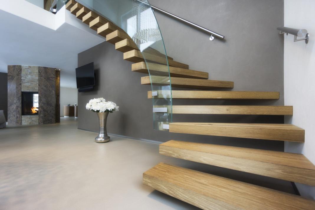 wooden staircase inside a luxurious house in a curved shape
