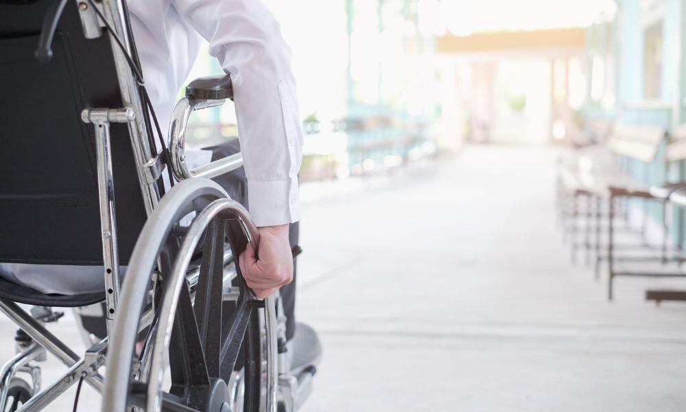 a person on a wheelchair riding on the floor on How To Ensure Your Wheelchair Is Consistently in Top Shape
