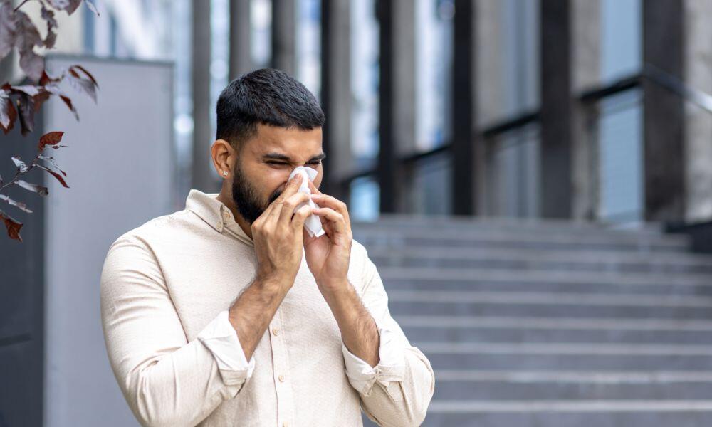 a person sneezing with a handkerchief for Managing Severe Allergies: Top 4 Safety Tips