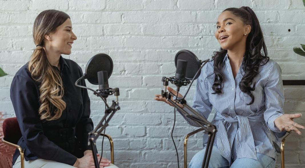 two ladies speaking over the mike to make a podcast