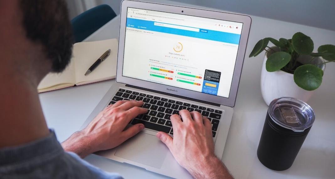 a person typing on the laptop to test the speed of the website