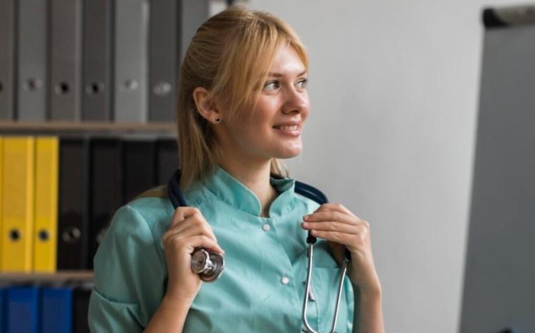 a lady doctor dressed in a gown with stethoscope around her neck. Ready to attend the patients.