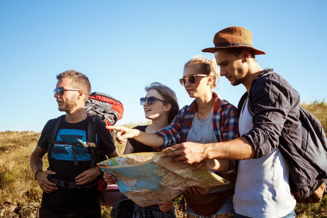 a group of travellers with their backpacks looking at a map