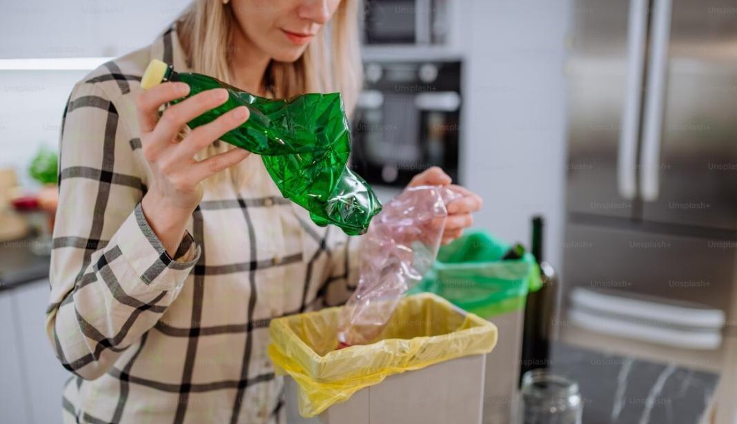 a woman removing the waste plastics from the house and placing them in a basket