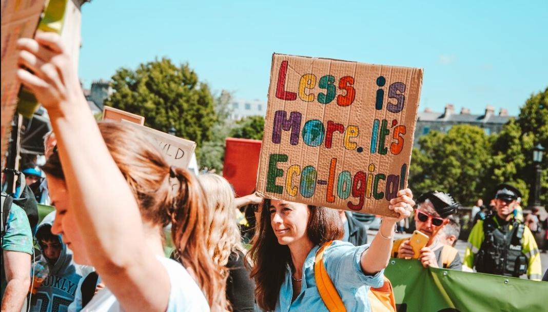 people protesting and walking on the sheets with chart papers signifying zero waste mindset
