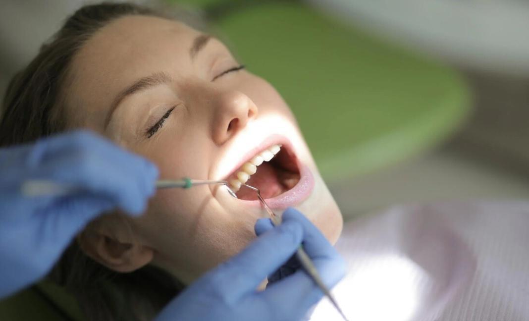 hands of the dentist holding the mouth of the patient during inspecting the teeth and gums for tooth care
