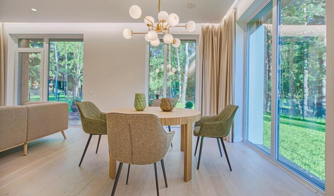 a house with beautiful curtain, chairs and window glass having green pastures outside