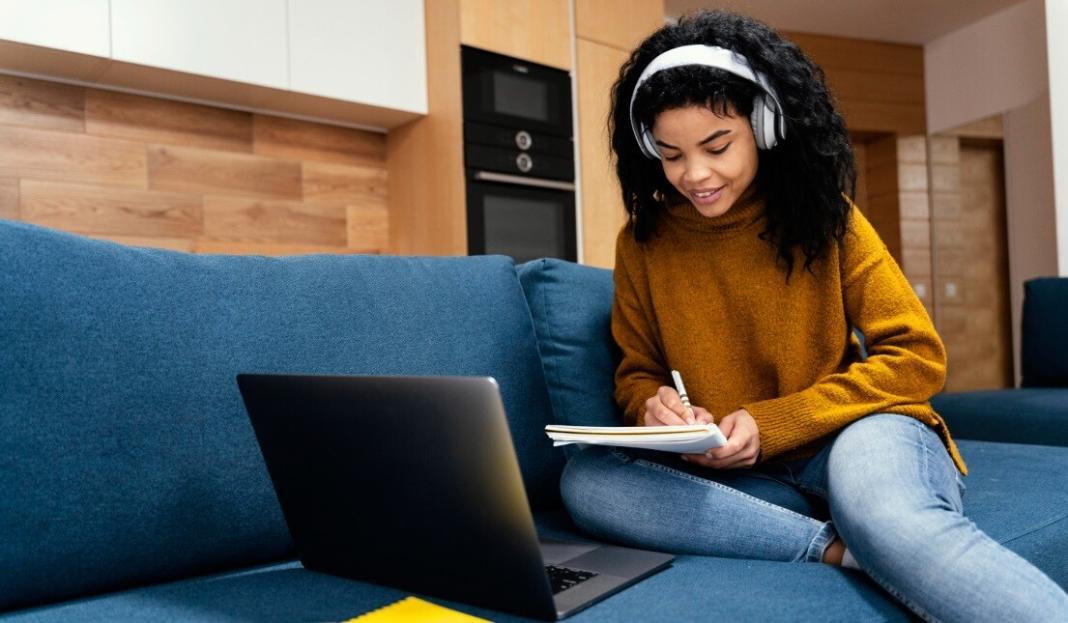 a girl child studying in front of the laptop to attend online class