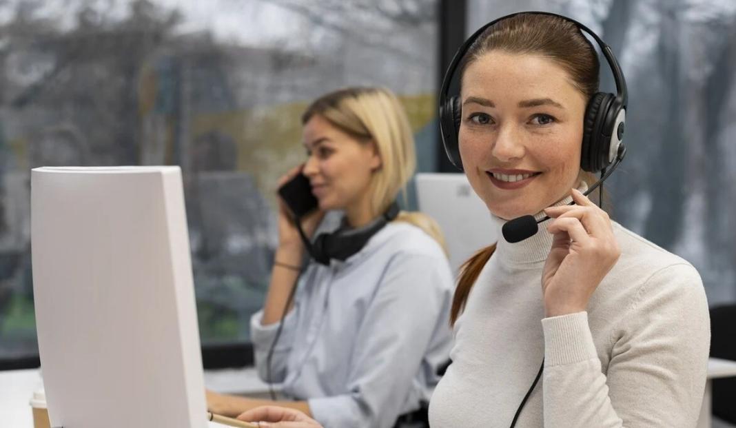 a lady speaking over calls adjacent to another lady with phone 