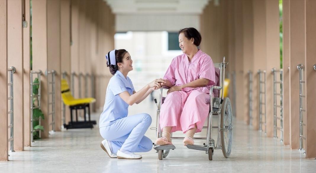 a lady with disability on a wheelchair assisted by another lady