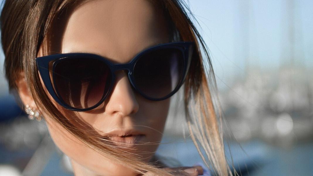 a lady wearing a beautiful sunglass and watching curiously 