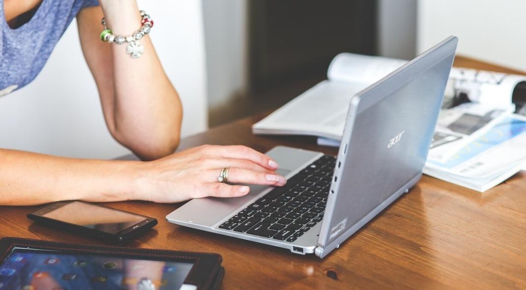 a person typing on a laptop and working on an accessible software