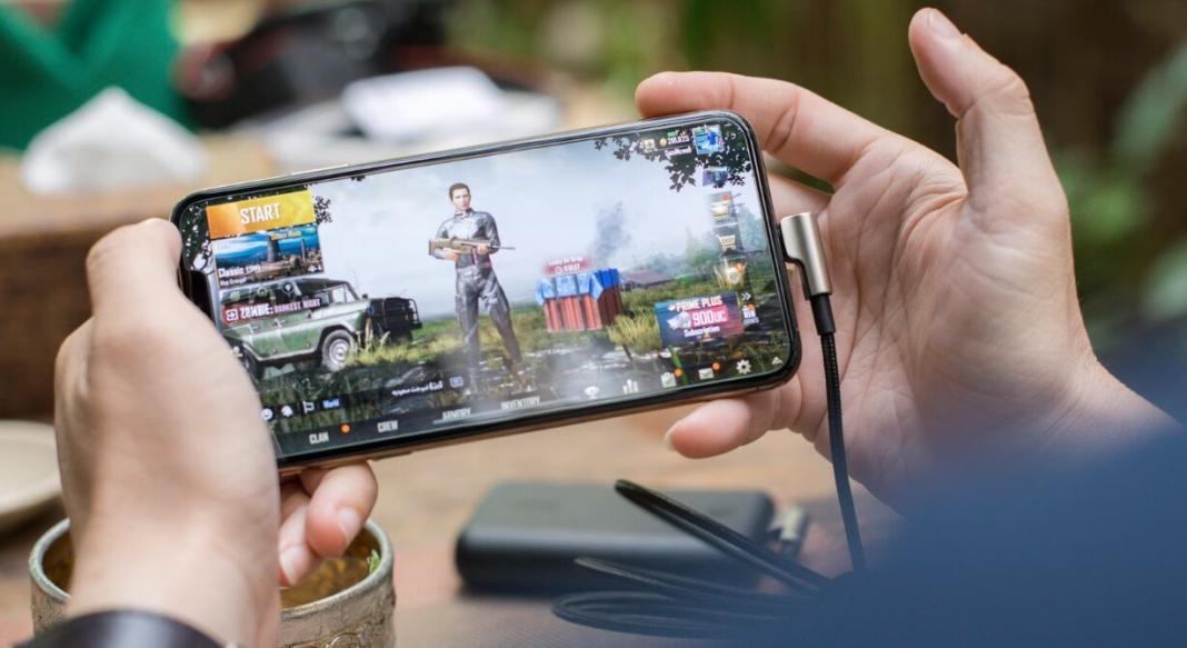 a man holding a mobile phone and playing a game