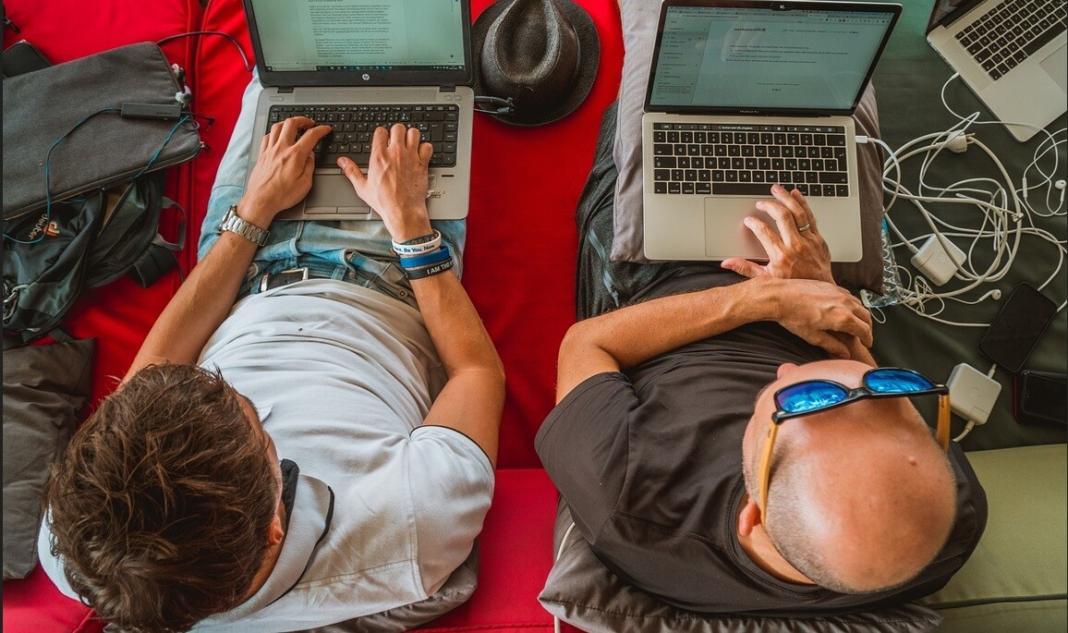 two persons working on their laptops idependently with their remote work