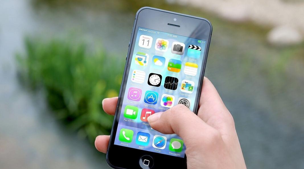 a person holding a mobile phone and navigating through the apps