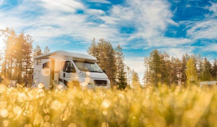 a caravan seen in the field with blue sky in the background