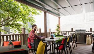 a man sitting on a chair and drinking coffee in a pergola