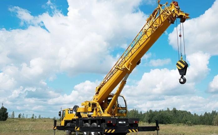 a long truck cane standing on the ground with clear blue sky in the background