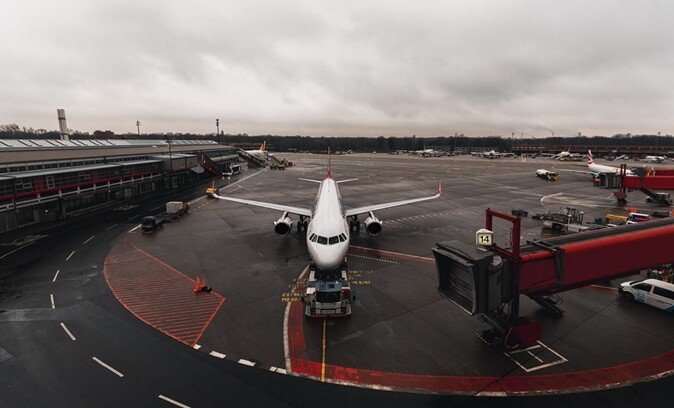 airplane on a tarmac ground parked due to the rain