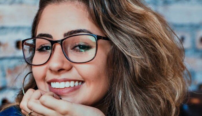 a lady with glass and brown hair smiling beautifully