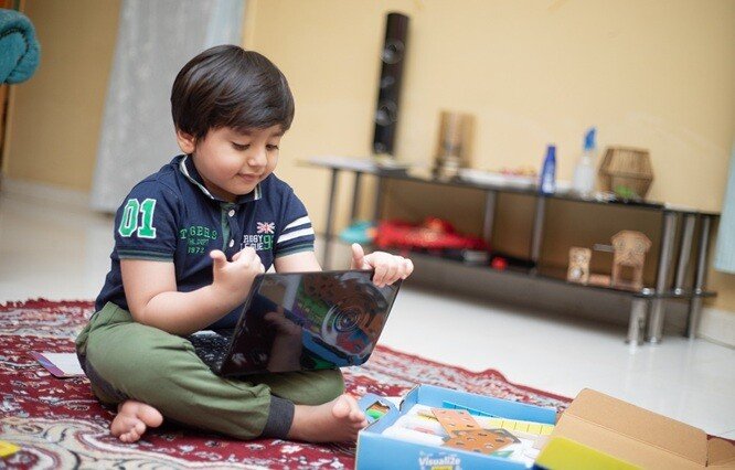 a boy using his laptop in his house and enjoying browsing