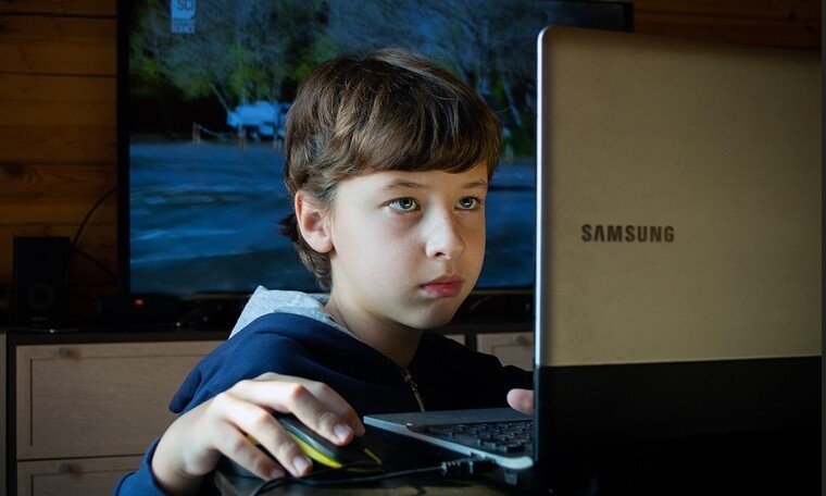 a boy using his laptop curiously to explore his networking friends