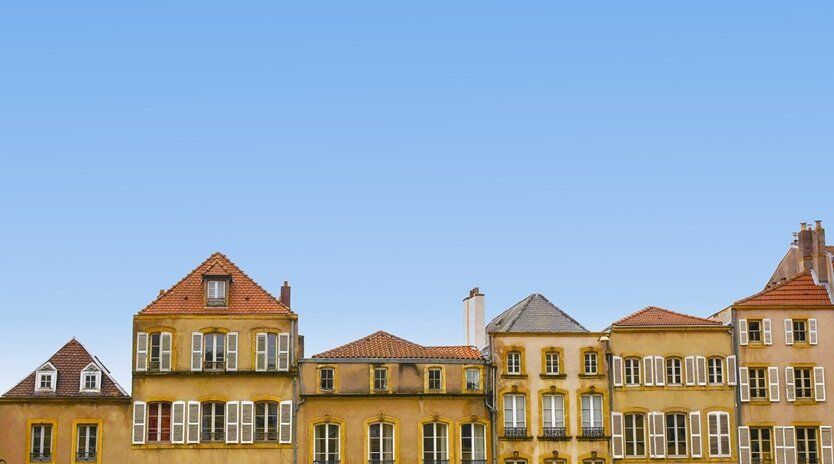a series of buildings adjacent to each other with clear blue sky