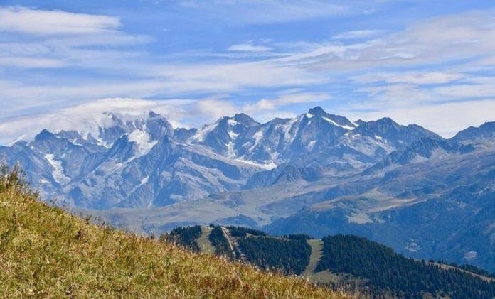 mountains in a clear sky and clouds with grasslands