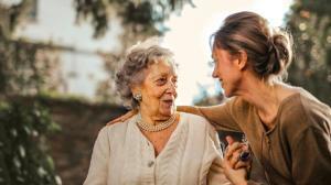 an elderly woman being taken care by another young lady in a care center