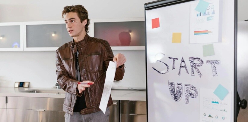 a young man standing and explaining the startup to investors