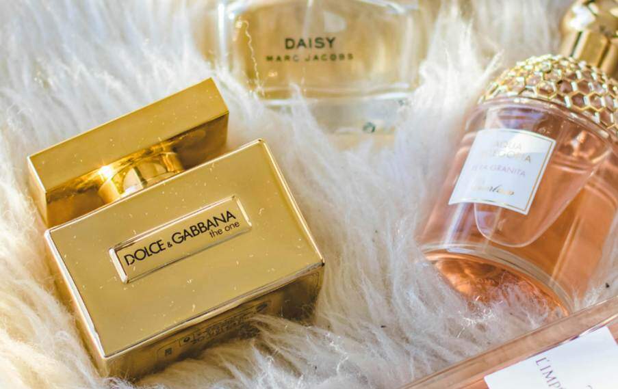 expensive perfume bottles displayed lying on a silk cloth