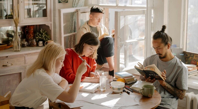 students preparing for exam at home with books, pen and tables