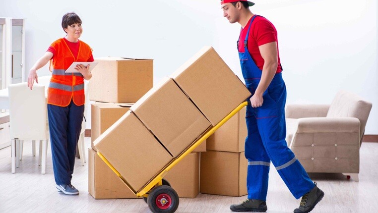 a person moving cartons using a movable machine from the house