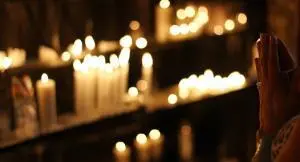 a number of candles lit on a praying center