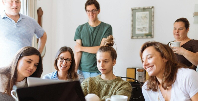 a group of people looking a laptop on AI applications