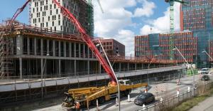 concrete pumping done at a construction site with a building in progress