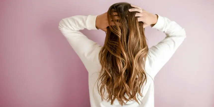 a lady standing showing her long hair on the backside