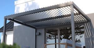 pergola seen in front of a white house in grey color