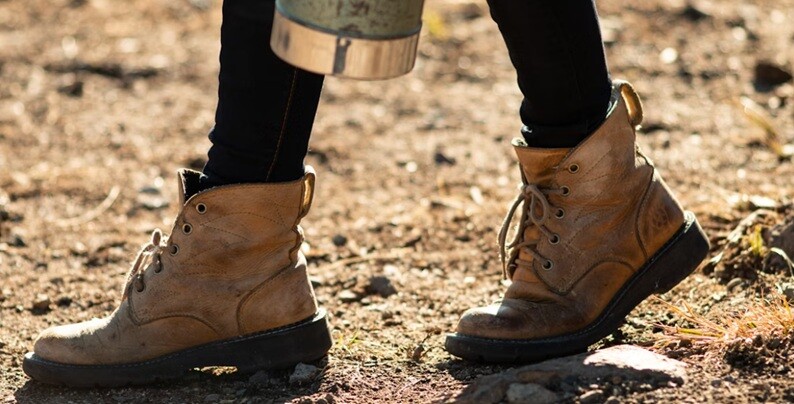 a lady wearing boots and walking in an hazardous place