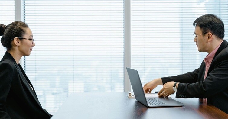 boss speaking to a lady employee in a office environment