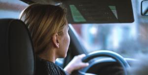a lady driving a car carefully focusing on the road