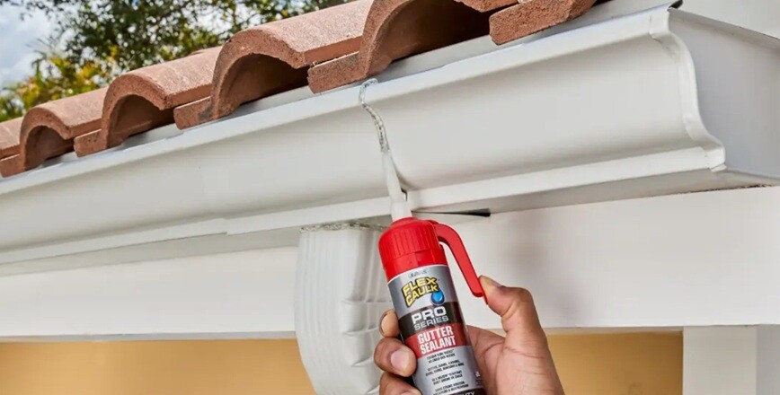 sealant gutter sealant held by a person and spraying on to house roof