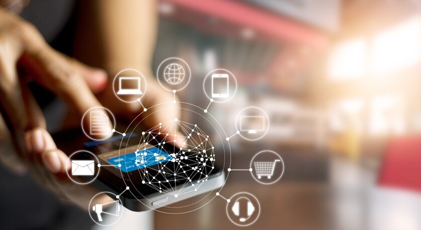 a person holding a mobile with digital gadget icons shown around it