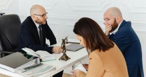 a lawyer speaking to a couple about their divorce acoss an office table